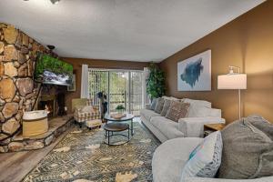 a living room with a couch and a stone wall at Bearadise Mountain Getaway by Eden Crest in Sevierville