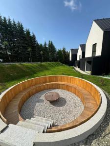 una hoguera circular en un patio con un edificio en Black Diamonds Hill en Istebna