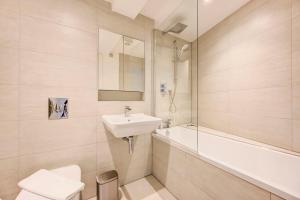 une salle de bain avec un lavabo, des toilettes et une baignoire dans l'établissement GuestReady - Modern Luxury near Tower Bridge, à Londres