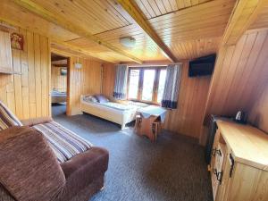 ポロニンにあるPokoje Skalnicaのキャビン内のソファとベッド1台が備わる客室です。