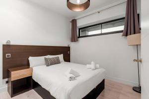 a bedroom with a large white bed and a window at GuestReady- Modern Aparthotel in Salamanca -Madrid in Madrid