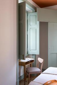 a bedroom with a desk and a chair and a window at GuestReady - Casas Do Tanoeiro in Porto Brandão