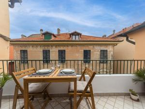 a wooden table and chairs on a balcony at Elegante a due passi dal mare in Alassio