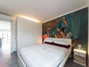 a bedroom with a large painting of flamingos on the wall at Elegante a due passi dal mare in Alassio
