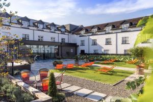an exterior view of a hotel with chairs and a garden at The Swan Hotel and Spa in Newby Bridge