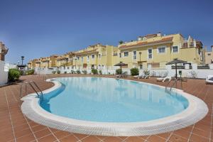 a large swimming pool in front of some buildings at Apartamento 104 in Caleta De Fuste