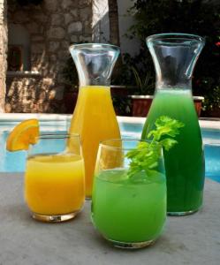three glasses of orange and green drinks on a table at Progreso Beach Hotel in Progreso