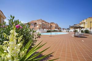 a courtyard with a pool and some buildings and flowers at Apartamento 104 in Caleta De Fuste