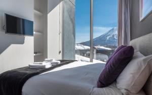 a bedroom with a bed with a view of a mountain at Terrazze in Kutchan +108 photos
