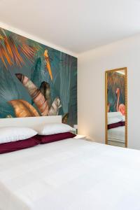 1 dormitorio con una gran pintura en la pared en Elegante a due passi dal mare, en Alassio
