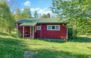 a red tiny house in a grassy field at 1 Bedroom Amazing Home In Väddö in Väddö +7 photos