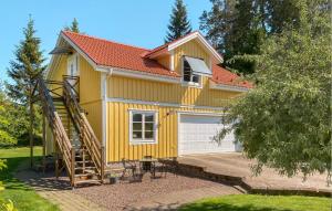 una pequeña casa amarilla con una escalera delante en Gorgeous Apartment In Hammar With Kitchen, en Hammarö