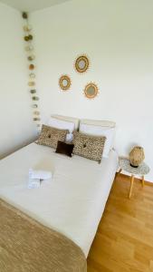 un letto bianco con cuscini sopra di Superbe appartement confortable, proche centre ville a Rennes