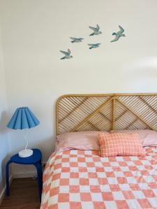een slaapkamer met een bed met vogels aan de muur bij Stylish Shack Falcon Bay in Wannanup