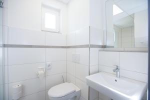 博爾庫姆的住宿－CVJM Freizeithaus MS Waterdelle，白色的浴室设有卫生间和水槽。