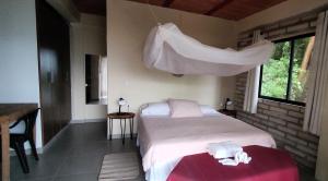 a bedroom with a bed with white sheets and a window at Edén Los Abuelos 2 - Casa Privada en Minca Nature in Minca