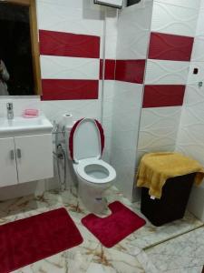 a bathroom with a toilet and red and white tiles at Appartement à Bouznika prêt du plage Dahomey, plage bouznika, Bahia beach in Bouznika