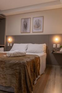 Un dormitorio con una cama grande con una manta. en Augusta Hotel en João Neiva