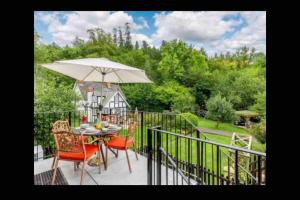 a patio with a table and an umbrella at Tank Barn at Brook House, Nestled in the Welsh Hills, a delightful retreat in Welshpool
