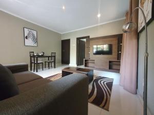 ein Wohnzimmer mit einem Sofa und einem Tisch in der Unterkunft Lotus by Serendib in Blantyre