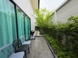 un balcon avec des chaises et des plantes dans un immeuble dans l'établissement PNT VILLA PATTAYa, à Nong Prue