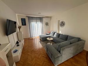 un salon avec un canapé gris et une télévision dans l'établissement Apartment Boomerang, à Ražanac
