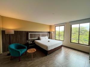 sypialnia z łóżkiem i niebieskim krzesłem w obiekcie Rado Hotel - Quintanas w mieście Trujillo