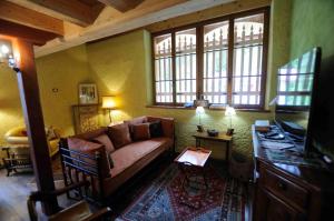 a living room with a couch and two windows at Chalet Pra Dell OSTIO Primiero San Martino di Castrozza in Fiera di Primiero