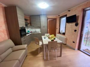 uma sala de estar com uma mesa e um sofá e uma cozinha em Dimora Gilles AO em Issogne
