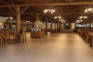 a large room with wooden tables and chairs at Hotel Fazenda Casarão do Vale in Massaranduba