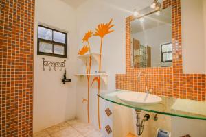 un bagno con lavandino e specchio di Woodstock Palmresort Curaçao a Willemstad