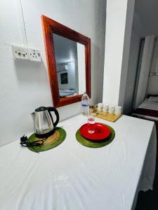 einen Tisch mit einem Wasserkocher und Tellern darauf in der Unterkunft Jaffna Palmyrah Hotel in Jaffna