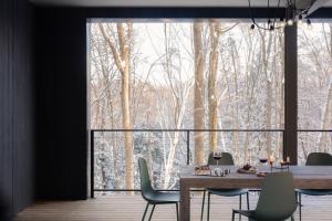 a dining room with a table and chairs and a large window at Idyll Reserve - Hocking Hills in South Bloomingville