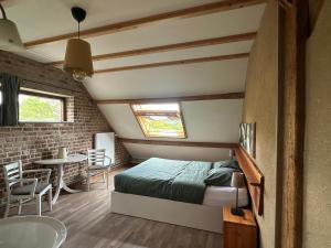 ein Schlafzimmer mit einem Bett und einem Tisch in einem Zimmer in der Unterkunft Landhuis Bovenste Bos in Epen
