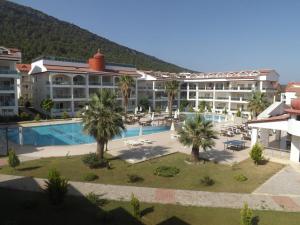 a resort with a swimming pool and palm trees at AKBÜK Palace Resıdence in Didim