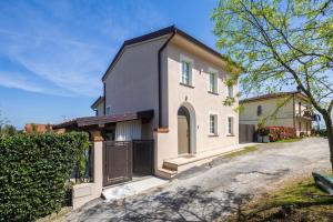 a white house with a black roof at Villetta Marice by VacaVilla in Stabbia