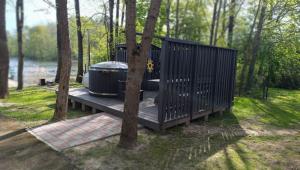 a wooden deck with two toilets on it next to trees at AB Imeda poilsiavietė in Ignalina +9 photos