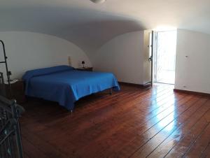 Schlafzimmer mit blauem Bett und Holzboden in der Unterkunft Threehouses in Trecase