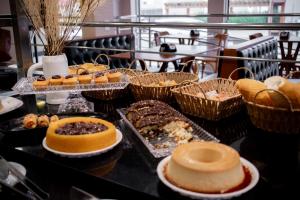 a buffet with many different types of pastries and cakes at Augusta Hotel by Samba in João Neiva
