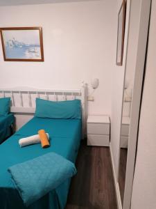 a small bedroom with a bed with blue sheets at Antomax Apartment in Costa del Silencio - WI FI in Costa Del Silencio
