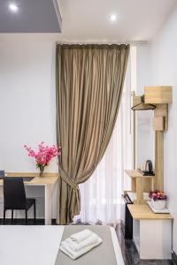 a room with a bed and a desk and a curtain at Bella Napoli Suites in Naples