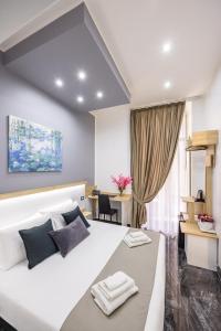 a bedroom with a large white bed and a desk at Bella Napoli Suites in Naples