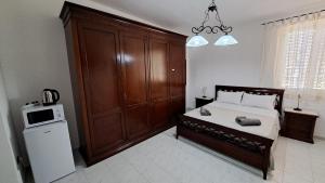 a bedroom with a bed and a large wooden cabinet at La Foggia seaside paradise in Siculiana