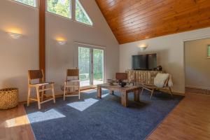 a living room with a table and chairs and a tv at Nature lovers delight, private hot tub and a short walk to Lake MI in Fennville