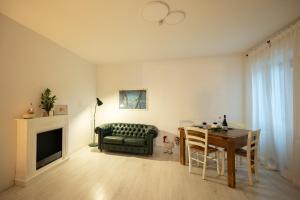 a living room with a table and a green couch at Casa Fulvia, Toscana in Castroncello