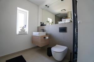 a bathroom with a white toilet and a sink at Residence Black&White in Ljubljana +21 photos