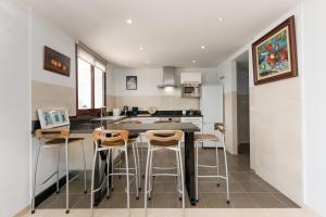 a kitchen with a table and some stools at Florida Home in Casares