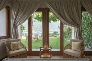 un soggiorno con due sedie e una grande finestra di Passalacqua a Moltrasio