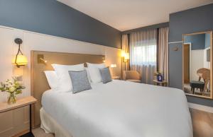 Postel nebo postele na pokoji v ubytování Hôtel Arcanse by Inwood Hotels
