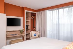 TV a/nebo společenská místnost v ubytování Hôtel Arcanse by Inwood Hotels